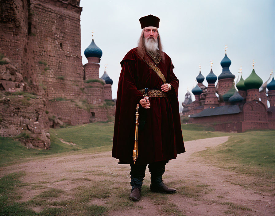 Russian man in traditional attire with sword at historic fortress