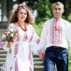 Couple in White and Red Traditional Attire on Forest Staircase