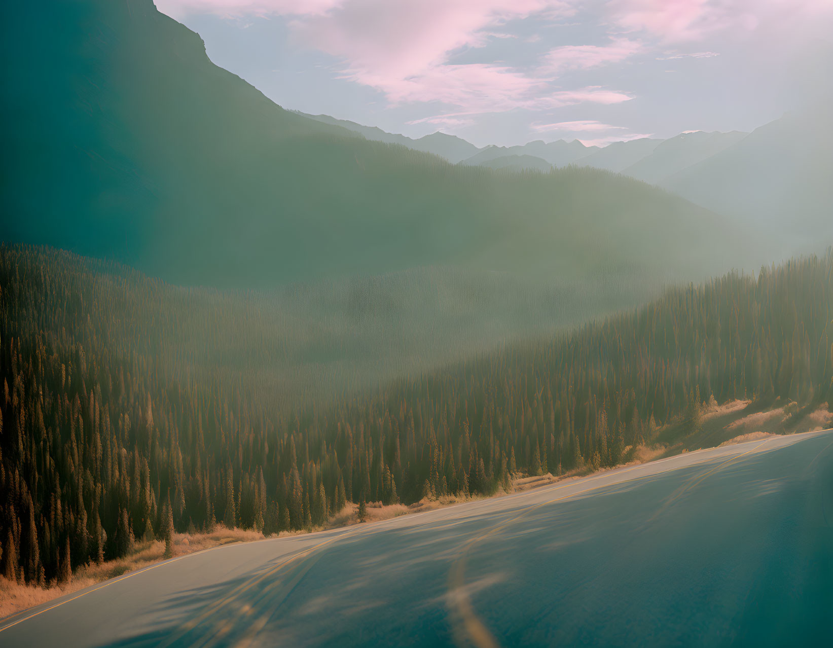 Curving Mountain Road with Pine Forests and Sunset Glow