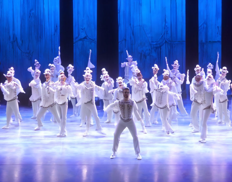 Ballet performance with dancers in white costumes on blue stage