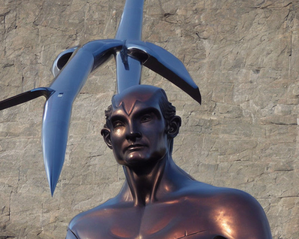 Bronze humanoid statue with propeller against textured wall