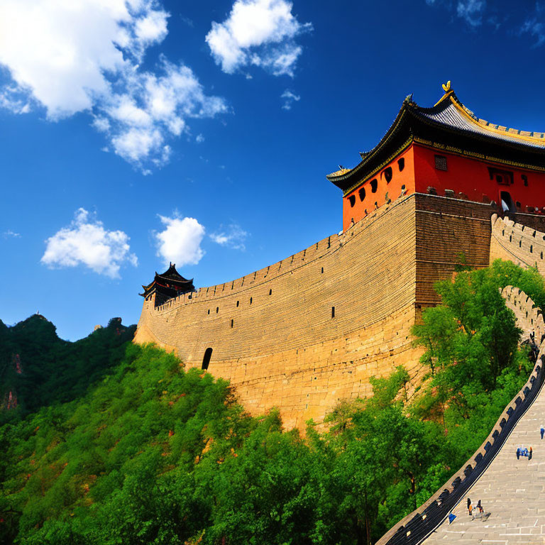 Great Wall of China section with watchtower winding through green hills under clear blue sky