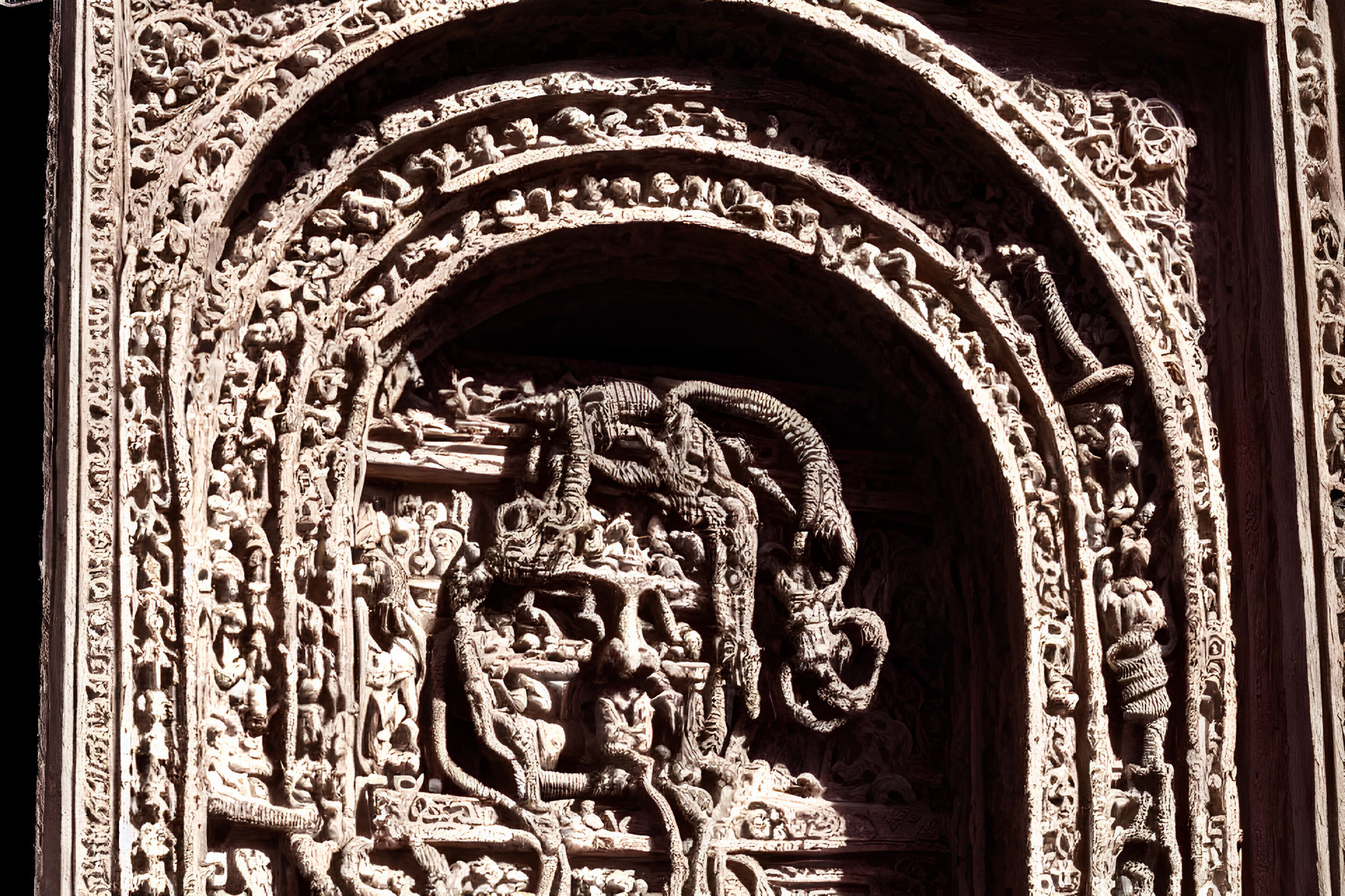 Intricate Hindu deity stone carving in temple arch