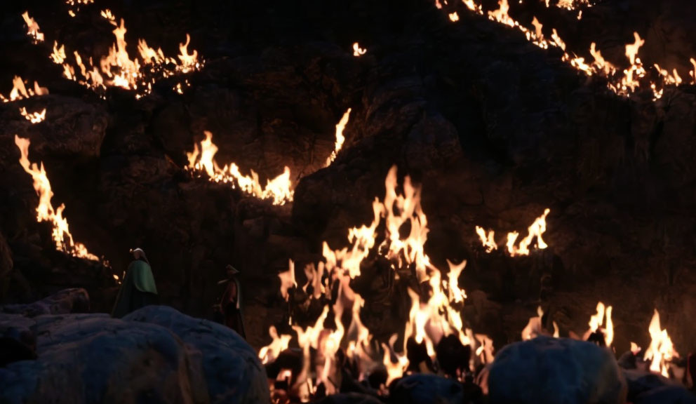 Nighttime scene with two figures and fires in rocky landscape