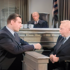 Lawyers in courtroom discussing with judge and another person.