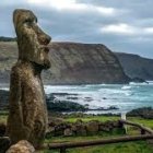 Digital illustration of Moai statue in coastal landscape with hills & sea.