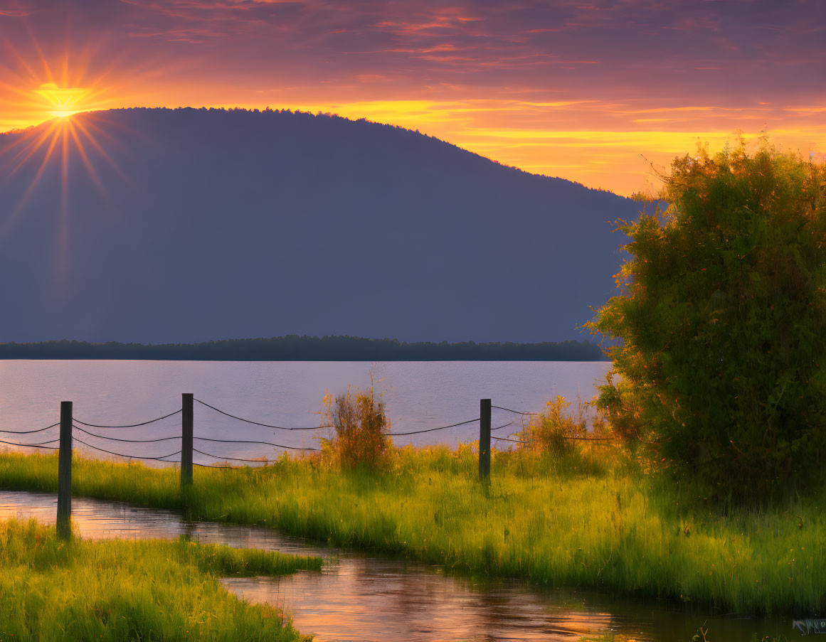 Tranquil lake at sunset with starburst effect and lush greenery