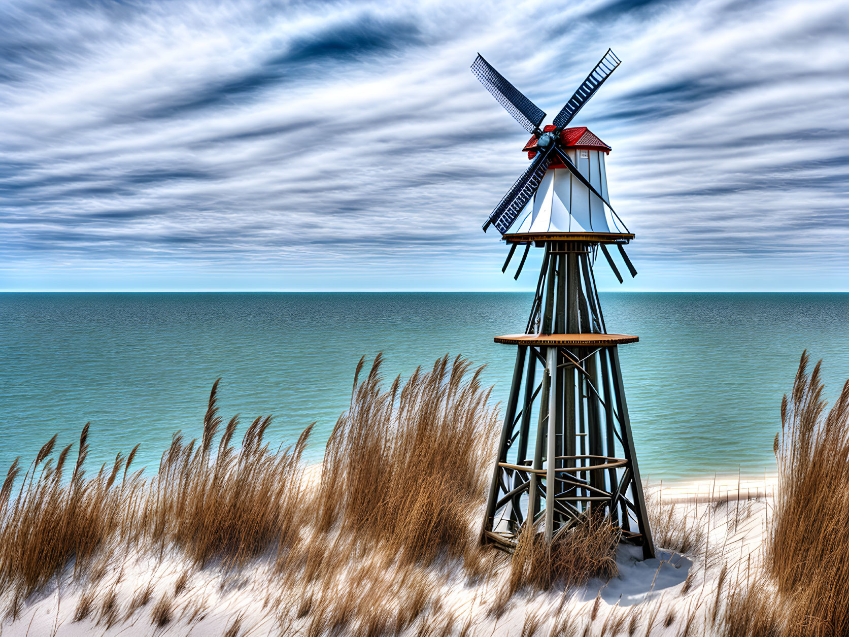 Traditional Wooden Windmill on Sandy Beach Overlooking Blue Sea