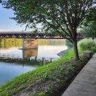 Scenic landscape mosaic with stone bridge, river, trees, rocks, blue sky