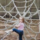 Child in Pink Top Climbing White Rope Net