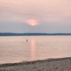 Tranquil sunset watercolor seascape with sailboats and pink sky