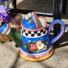 Colorful Polka-Dotted Watering Can Surrounded by Flowers and Tools