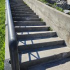 Sunlit outdoor staircase with overgrown greenery casting soft shadows