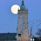 Twilight church illustration with lit windows, full moon, and flying birds