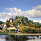 Scenic village with quaint houses on hill by serene river