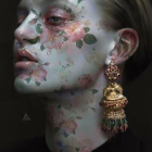 Ethereal portrait of woman with luminous skin and gold-tinged flowers