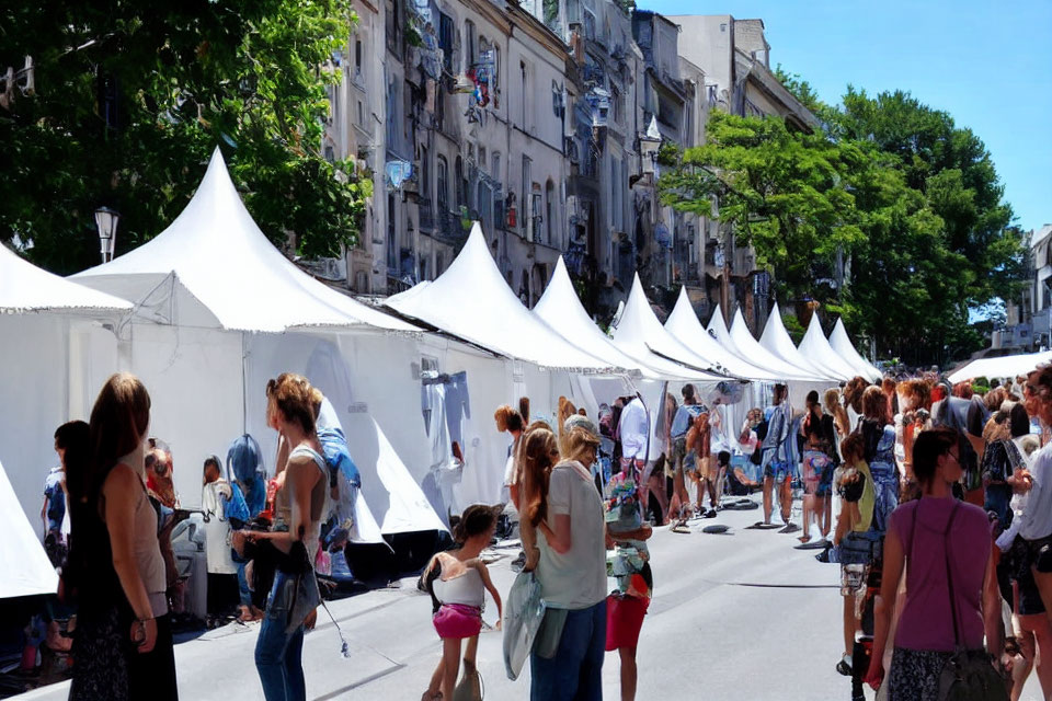Outdoor Street Fair with White Tents, Vendors, and Crowd Amid Urban Setting