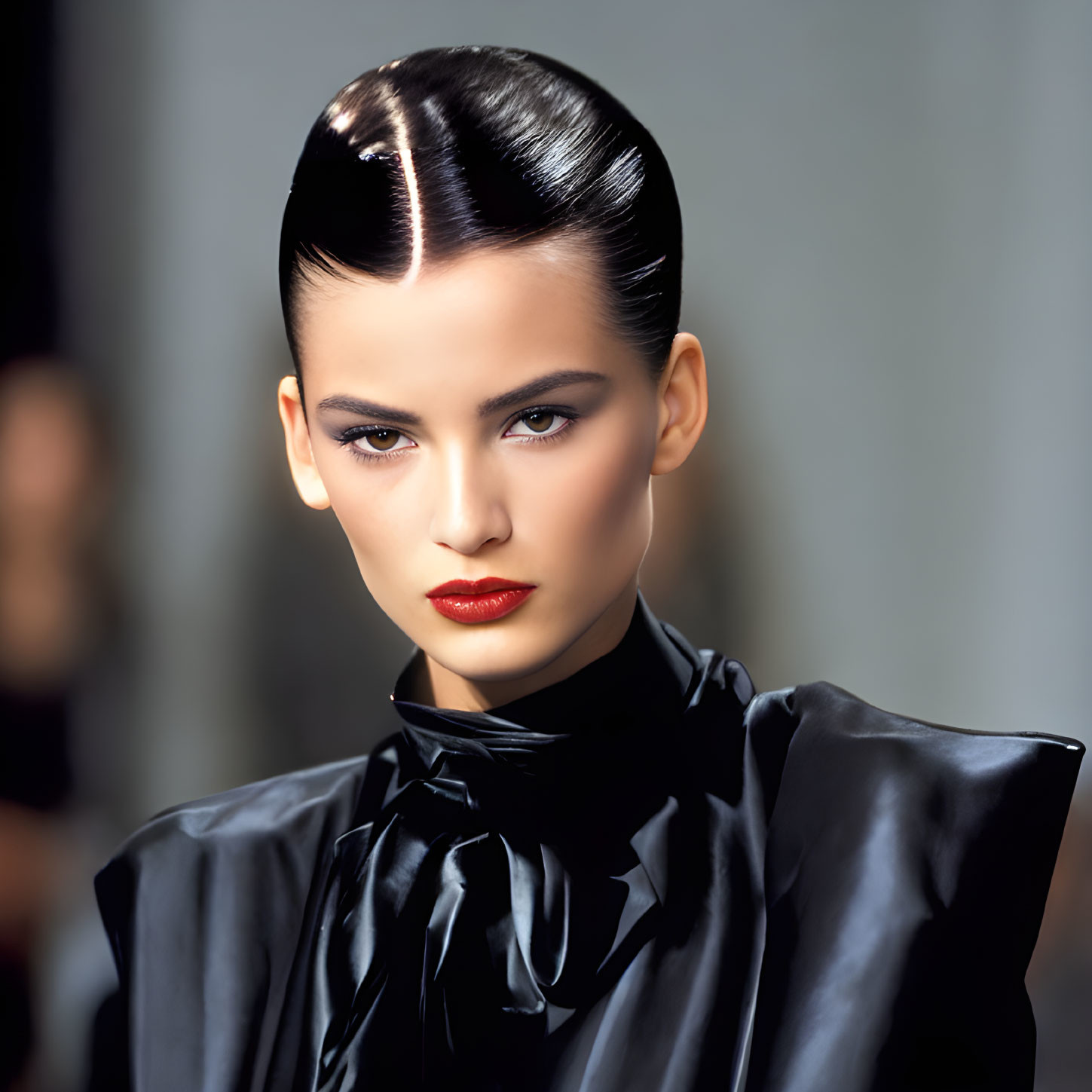 Fashionable woman in black outfit with red lipstick and slicked-back hair