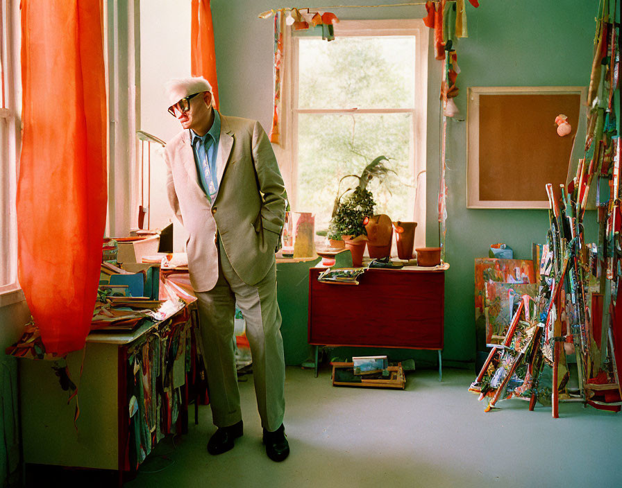 Person in Light Suit and Sunglasses in Colorful Eclectic Room Full of Books and Art