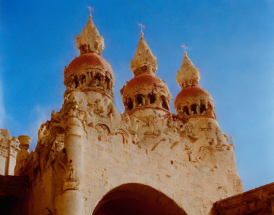 Stone structure with ornate domes under blue sky