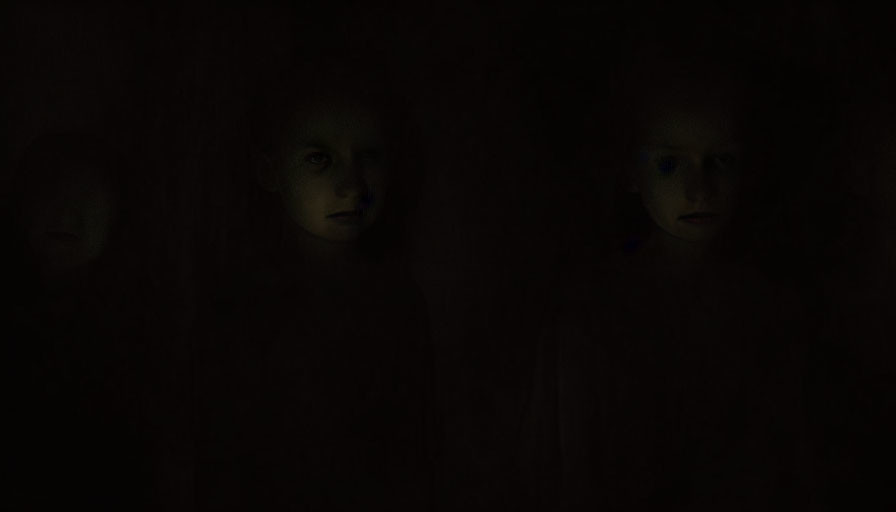 Faintly visible children's faces in dark background