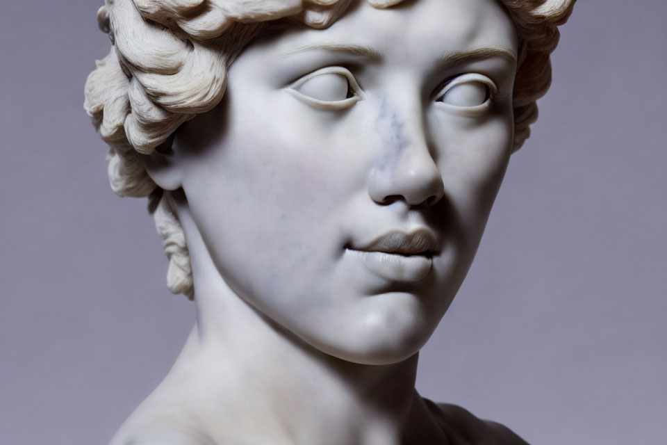 Classical marble sculpture of person with curly hair and serene expression