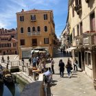 Vibrant Venetian canal with colorful buildings and gondolas under clear blue sky