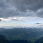 Abstract Landscape: Swirling Clouds, Mountains, and Foliage in Cool Colors