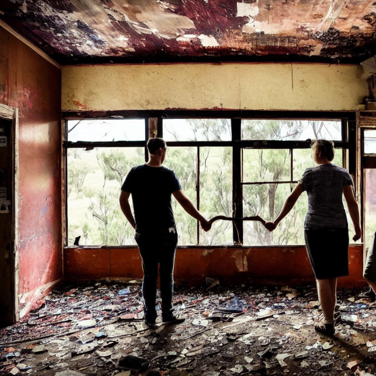 Abandoned room scene: Two people holding hands by window