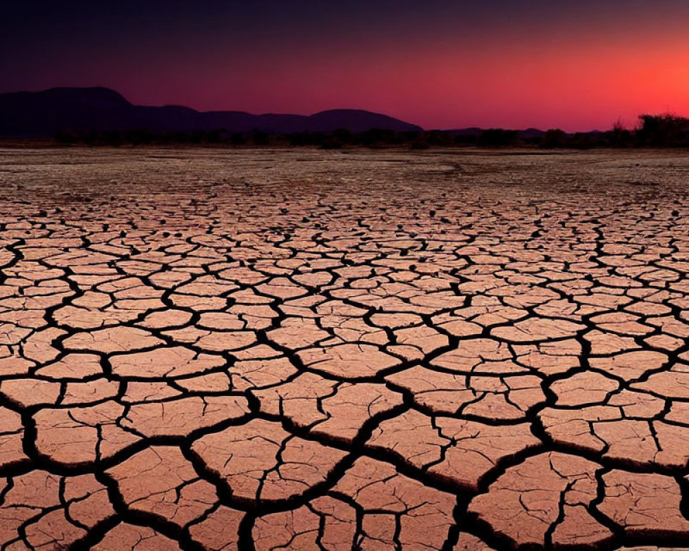 Cracked Earth Under Vibrant Sunset Sky