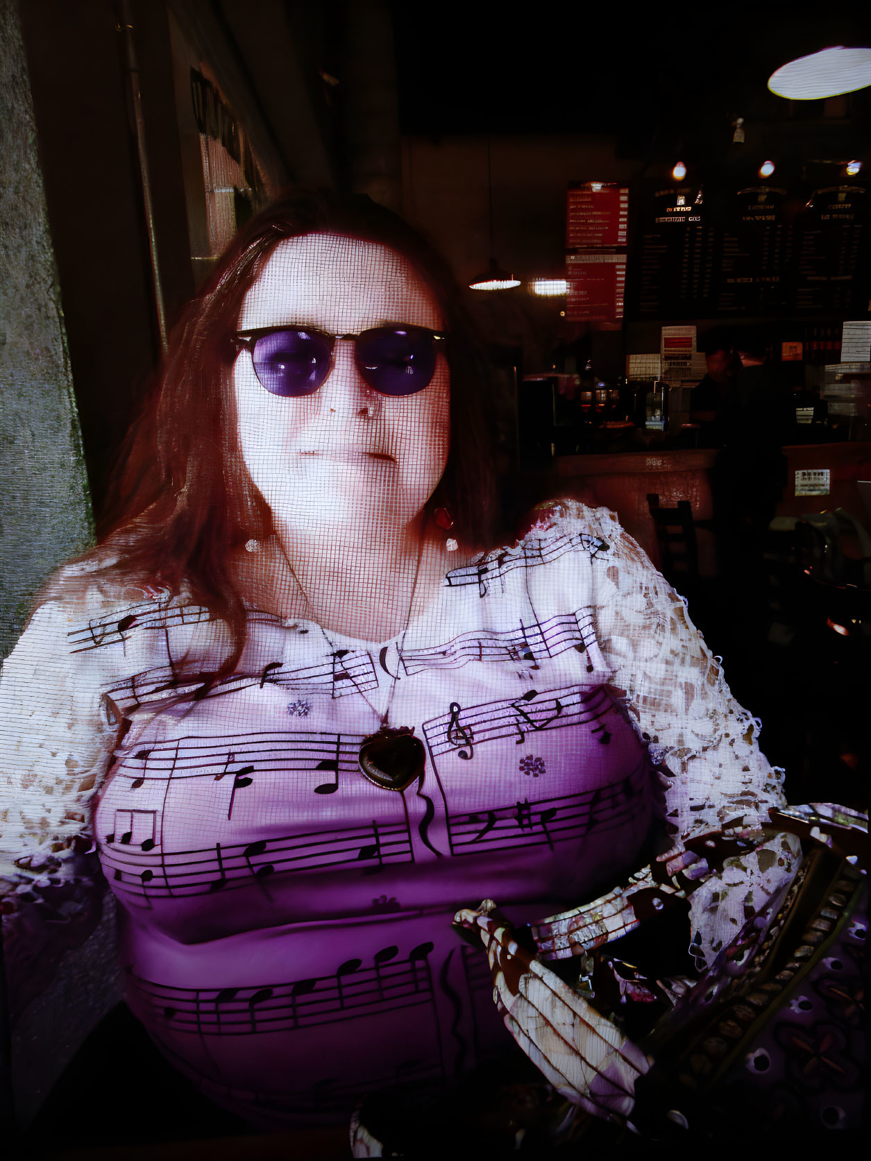 Woman in sunglasses with purple top at cafe table.