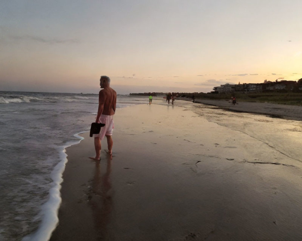 Individual on beach at dusk with ocean view and cloudy sky.