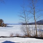 Frozen River with Ice Skating People in Winter Scene