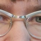 Detailed Close-up of Green Eyes with Cat-eye Glasses and Curly Hair