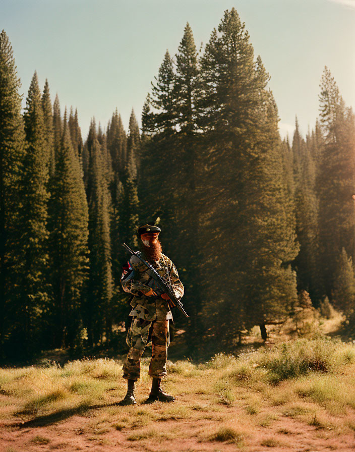 Camouflaged person with rifle in forest clearing