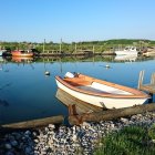 Tranquil scene of white boat on wooden dock in serene blue waters