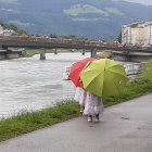 Colorful Impressionist Painting of People with Umbrellas Walking in City