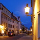 Historically dressed couple strolling on cobblestone street at dusk