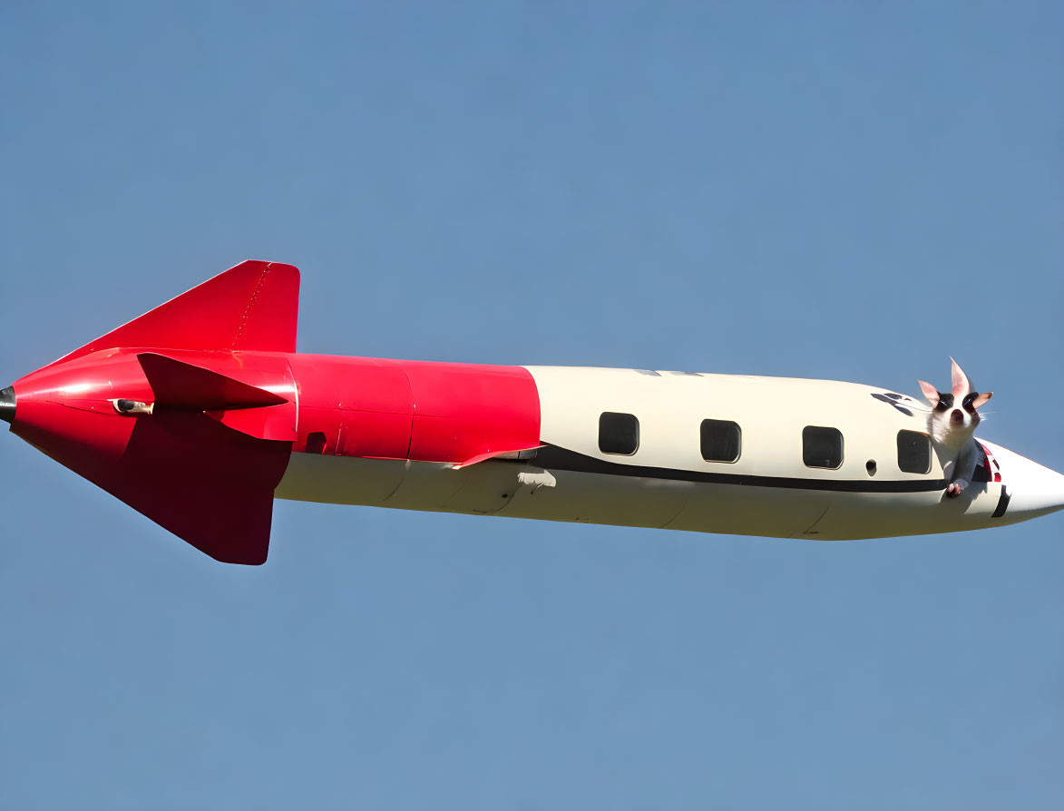 Red and White Missile-Styled Airplane Flying in Clear Blue Sky