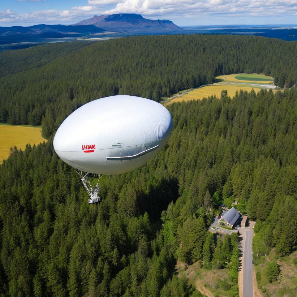 Airship flying over forested area with road and fields under blue sky