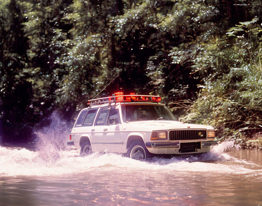 Emergency Vehicle Drives Through High Water with Red Lights in Flooded Area