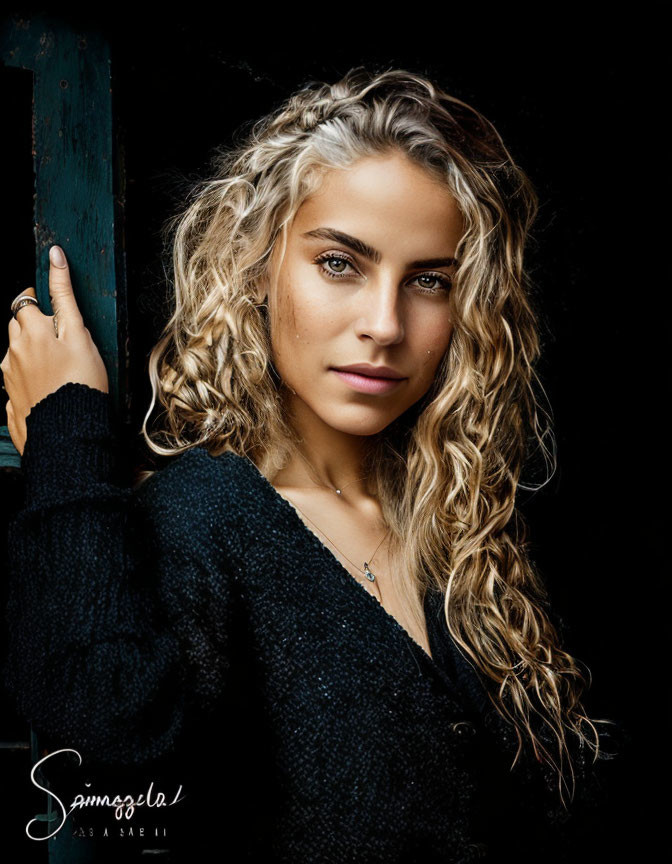 Blonde woman in black sweater with curly hair and wooden frame