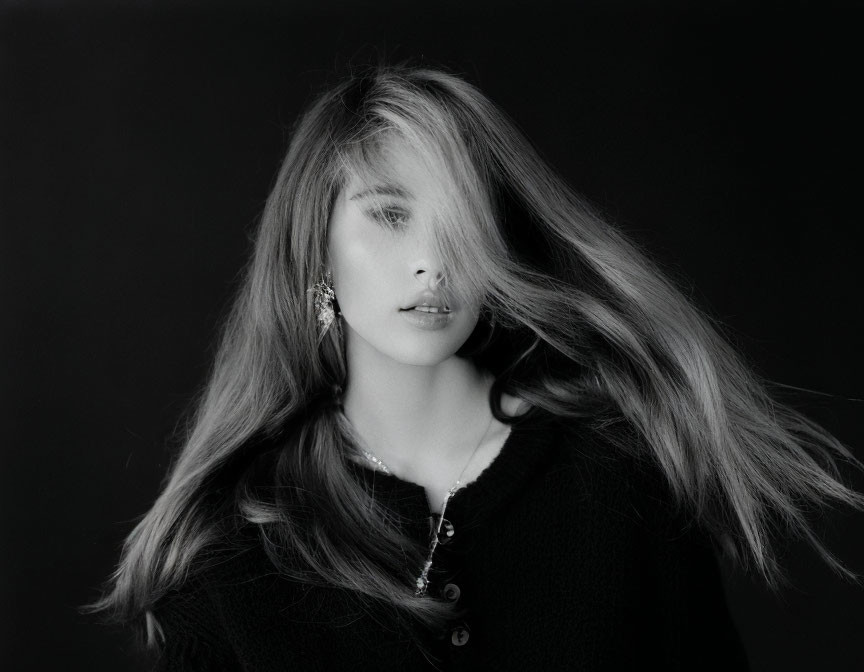 Monochrome portrait of a woman with flowing hair and earring