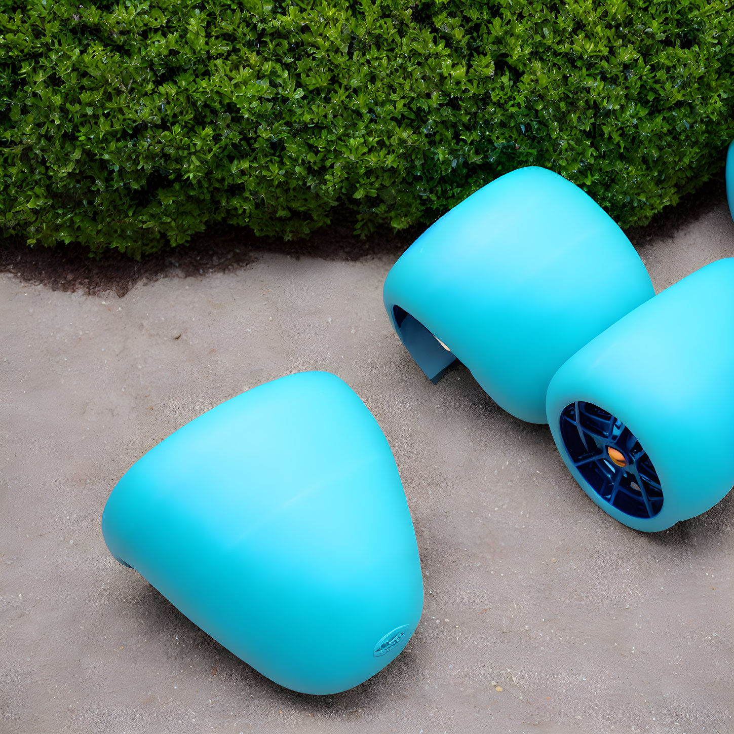 Blue Outdoor Speakers Overturned on Sand near Green Hedge