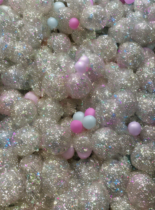 Pastel-colored glitter balls and scattered balloons.