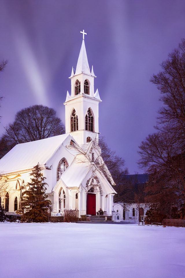 Snow-covered church with white steeple under purple twilight sky