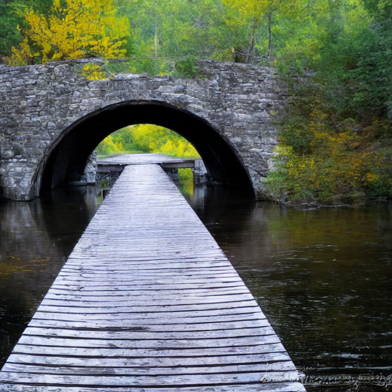 Wooden Dock Leading to Stone Arch Bridge over Tranquil River and Autumn Trees