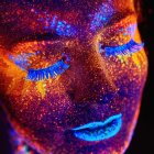 Colorful woman portrait with cosmic face paint and sparkling stars for a dreamy look