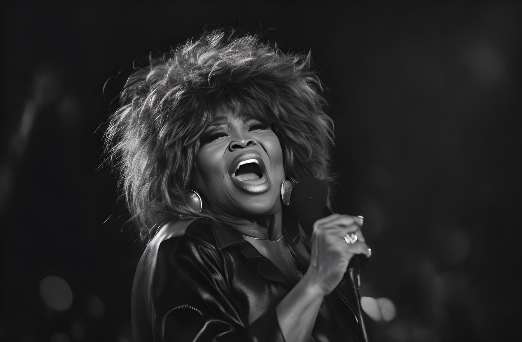 Monochrome image: Woman singing passionately with wild styled hair