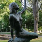 Black Woman Sculpture Interacting with Wavy Structure in Green Park